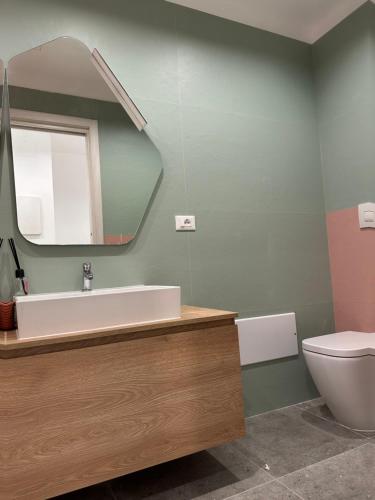 a bathroom with a sink and a mirror and a toilet at Appartamento intero in Pieno Centro in Cassino