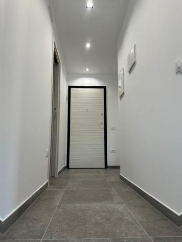 a white hallway with a door and a tile floor at Appartamento intero in Pieno Centro in Cassino