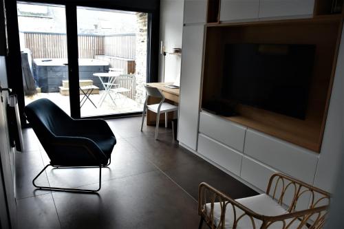 a living room with a chair and a television at La Maison du Quai Triplex de charme 4 étoiles en hyper centre avec SPA in Landerneau