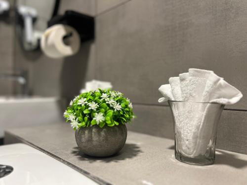 a bathroom counter with a vase with a plant on it at K AVENUE - 2 Bedroom with Privacy Balcony by Akinabalu Family Homestay in Donggongon