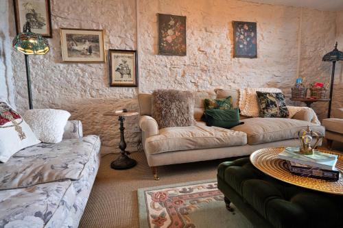 a living room with two couches and a table at Finest Retreats - Blackclough Farmhouse at Blackclough Farm in Buxton