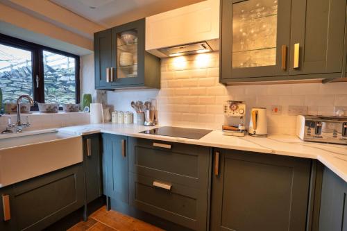 a kitchen with blue cabinets and a sink at Finest Retreats - Blackclough Farmhouse at Blackclough Farm in Buxton