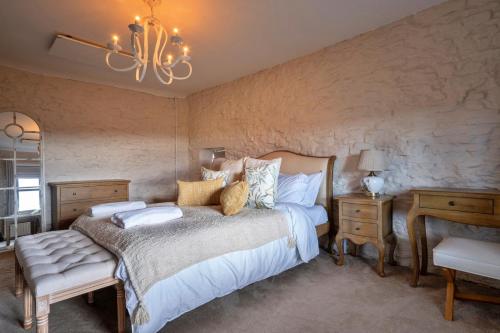a bedroom with a large bed and a chandelier at Finest Retreats - Blackclough Farmhouse at Blackclough Farm in Buxton