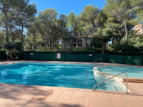 une grande piscine avec de l'eau bleue dans l'établissement Bel appartement à 5 mn de la mer et du centre-ville - Résidence Les Gémeaux, à Saint-Aygulf
