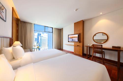 a hotel room with a bed and a desk at Green Beach Hotel Nha Trang in Nha Trang