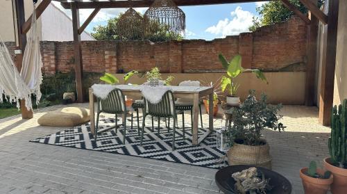 a table and chairs on a patio with plants at La Casita Nazaré - private pool in Nazaré