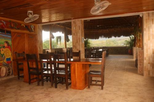 a dining room with a wooden table and chairs at Hotel Malibu in San Juan Nepomuceno
