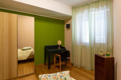 a room with a desk and a bed with a green wall at San Lorenzo B & B in Ruoti