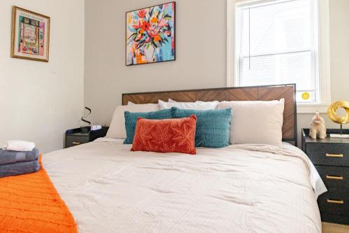 a bedroom with a bed with orange and blue pillows at Stylish & Family Friendly 2BR at Downtown Washington DC in Washington, D.C.