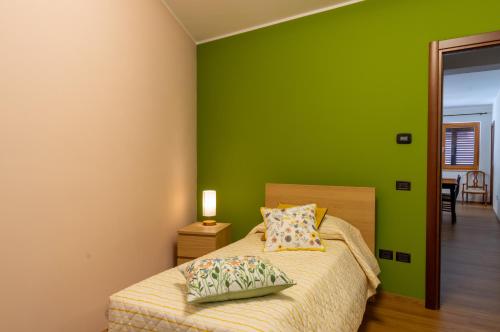 a bedroom with green walls and a bed with two pillows at San Lorenzo B & B in Ruoti