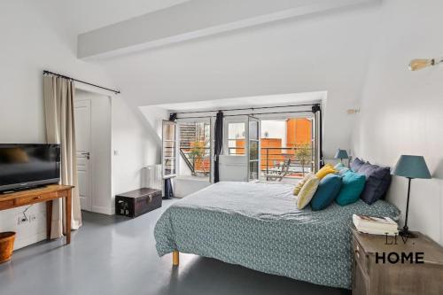 une chambre avec un lit et une télévision à écran plat dans l'établissement Triplex Atypique à 10mn de Paris, à Boulogne-Billancourt