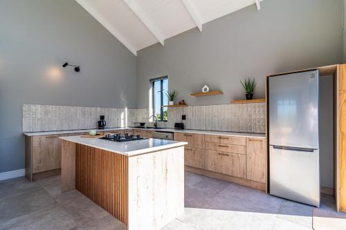 a large kitchen with wooden cabinets and a white refrigerator at 401 Kingfisher in Gansbaai