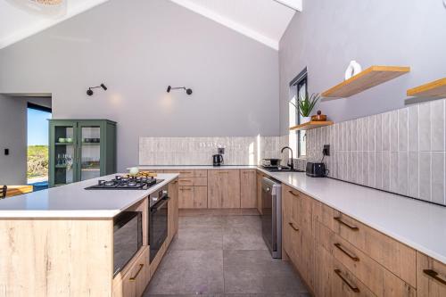 a kitchen with wooden cabinets and a stove top oven at 401 Kingfisher in Gansbaai