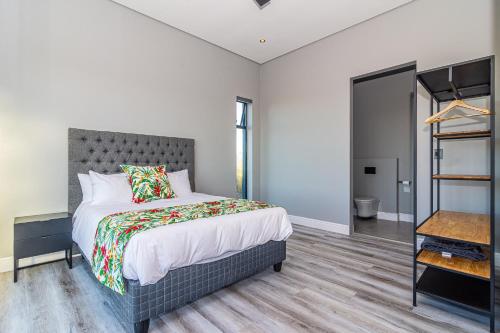 a bedroom with a bed with a gray headboard at 401 Kingfisher in Gansbaai