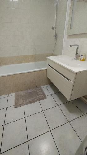 une salle de bain avec un lavabo, une baignoire et une douche dans l'établissement Appartement T3 proche de Bâle, à Saint-Louis