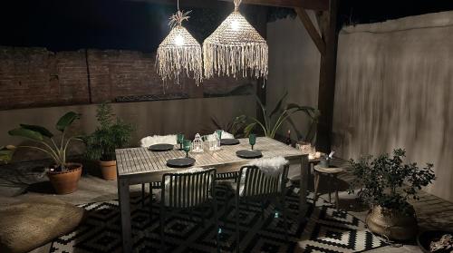 a dining room table with chairs and chandeliers at La Casita Nazaré - private pool in Nazaré