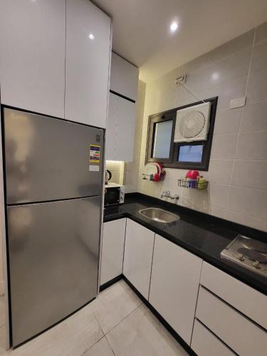 a kitchen with a stainless steel refrigerator and a sink at Madinity B8 - Fantasy Studio in Madinaty