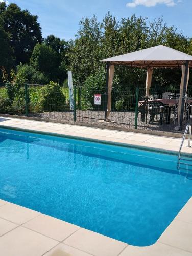 - une piscine avec un kiosque et une table dans l'établissement Les Poiriers, à Saint-Pierre-du-Chemin