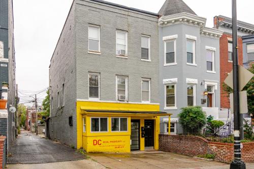 a yellow and gray building on a street at Stylish & Family Friendly 2BR at Downtown Washington DC in Washington, D.C.
