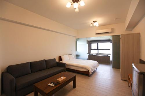 a living room with a couch and a bed at 晨曦溫泉宅 in Toucheng