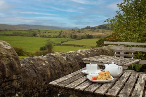 a table with a plate of food and tea on it at Shepherds Hut at Maes Uldale in Uldale
