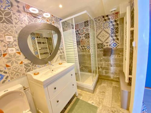 un bagno con lavandino, doccia e specchio di Le Prestige des Papes-Élégance Confort Cœur d'Avignon ad Avignone