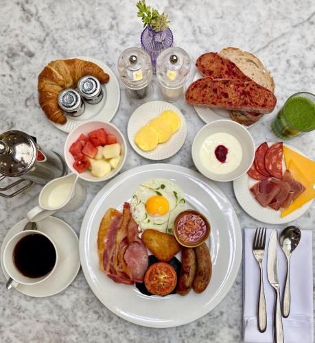 a table topped with plates of breakfast foods and coffee at Gonville Hotel in Cambridge