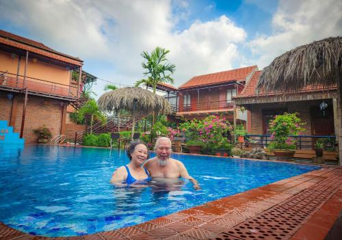 a man and woman in the swimming pool at a resort at Trang An Village Homestay in Ninh Binh