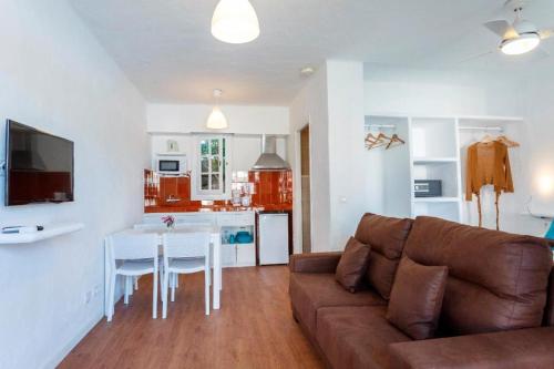 a living room with a couch and a table and a kitchen at FERGUS Club Carema Splash in Fornells