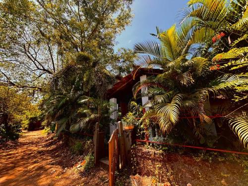 a house with palm trees next to a fence at Bramha Home Stay in Canacona