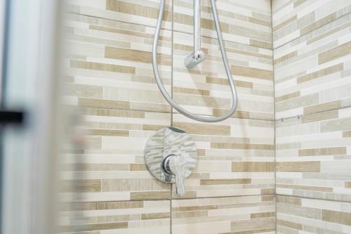 a shower with a shower head hanging from a wall at Dodo's house in Bari