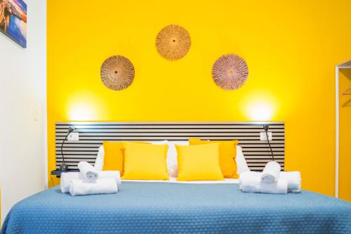 a yellow bedroom with a blue bed with yellow pillows at Dodo's house in Bari