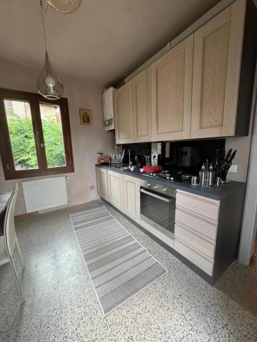 a kitchen with wooden cabinets and a stove top oven at Comfortable apartment in Castell'Arquato of 80 m² in CastellʼArquato