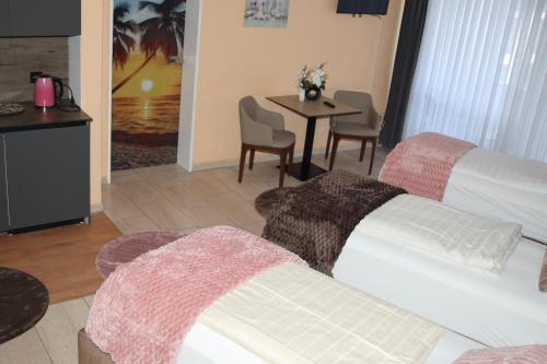 a room with a bed and a table with chairs at Hotel Hafez in Bad Salzuflen