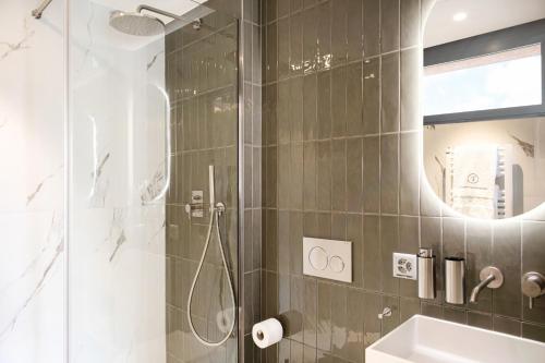 bagno con doccia, lavandino e specchio di VISIONAPARTMENTS Lugano - contactless check-in a Lugano