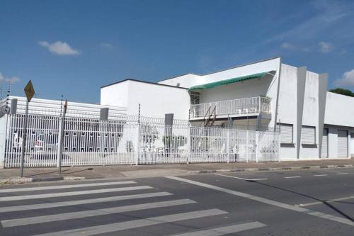 ein weißes Gebäude mit einem Zaun neben einer Straße in der Unterkunft Apto Diamante in Boa Vista