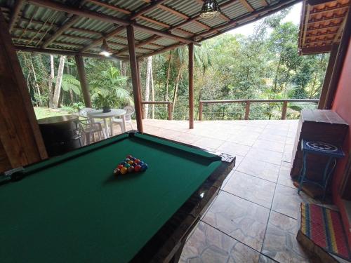 a pool table on a screened in porch with a pool table at Casa de Campo Rio Miguel in Aguas Mornas