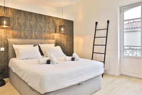 - une chambre avec un grand lit blanc et une échelle dans l'établissement Villa luxueuse au pied de la plage, à Les Sables-dʼOlonne