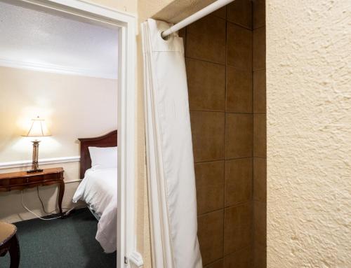 a bedroom with a bed and a door leading to a shower at Lake Lure Inn and Spa in Lake Lure