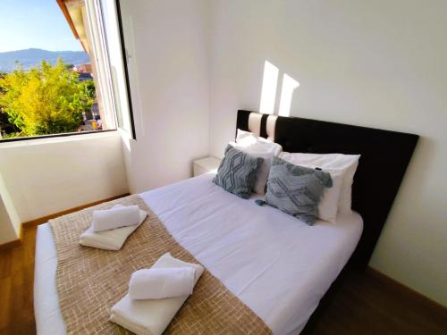 a bedroom with a white bed with pillows and a window at Sea House in Funchal