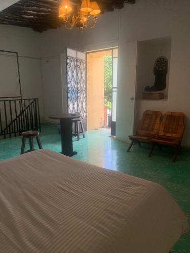 a room with chairs and a bed and a chandelier at casa pich balam in Valladolid