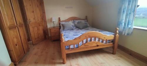 a bedroom with a wooden bed and a window at Luxurious Self Catering House in Co Donegal in Letterkenny