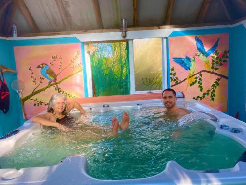 a man and a woman in a hot tub at Driftwood Country Apartment in Skibbereen