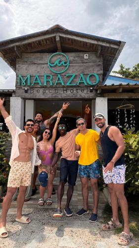 a group of people standing in front of a sign at Marazao Beach Hotel & Spa in Tierra Bomba