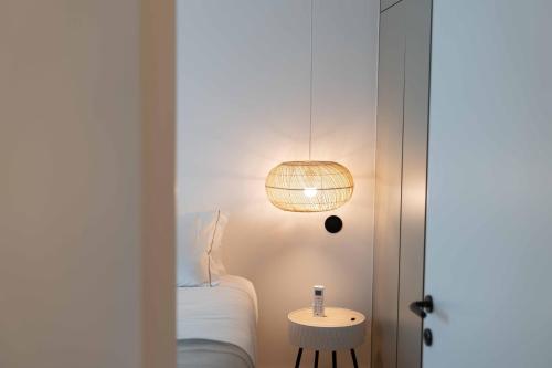 a room with a bed and a lamp and a table at Design Apartment by The Farm - Azores Boutique House in Ponta Delgada