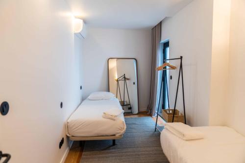 a room with two beds and a mirror at Design Apartment by The Farm - Azores Boutique House in Ponta Delgada