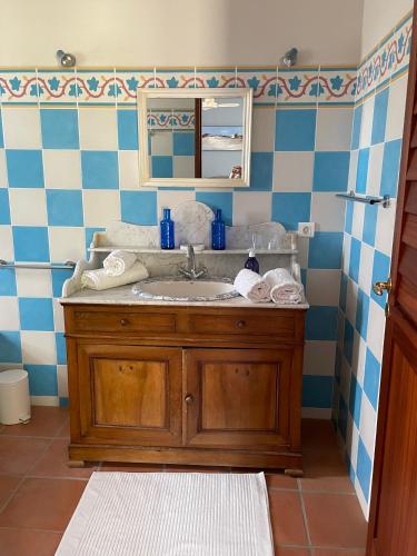 une salle de bain avec un lavabo et un miroir dans l'établissement Mas Vigneron, à Gruissan