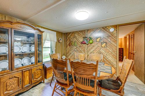 a dining room with a table and a china cabinet at Creek Access and Spacious Yard Quiet Sylva Home! in Sylva