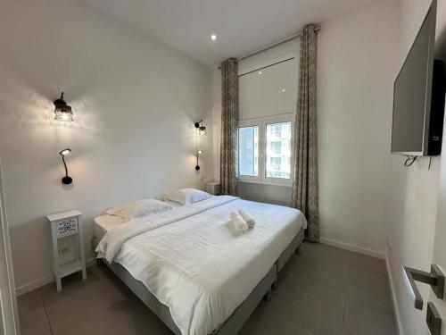 une chambre avec un grand lit avec une fenêtre dans l'établissement B080- À l'étroit à l'hôtel Bienvenue chez nous, à Cannes