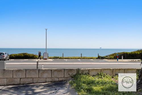 a person walking on a road near the ocean at Oceanfront Oasis in Bunbury